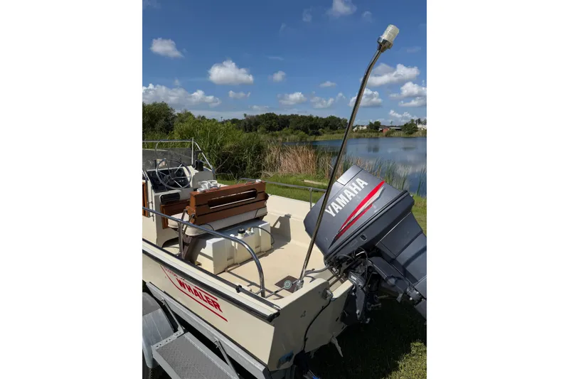 Slide: The Image of 1987 Boston Whaler 17 Montauk boat with Yamaha motor by a lake. - 7