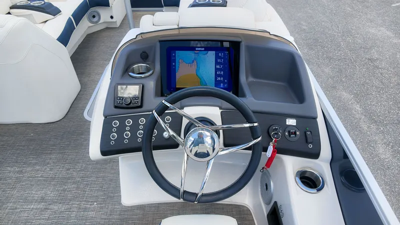 Slide: The Image of The image shows the helm of a Bennington 25 QFBA boat with a modern navigation system. - 24