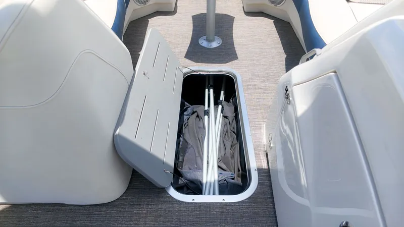 Slide: The Image of An open storage compartment on a boat reveals poles and a cover. - 15