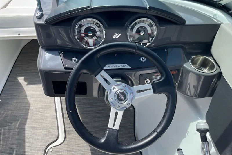 Slide: The Image of Steering wheel and dashboard of 2020 Four Winns H190 boat, featuring sleek design and controls. - 13