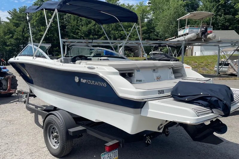 The Image of 2020 Four Winns H190 boat on trailer, featuring sleek design and navy blue accents. - 1