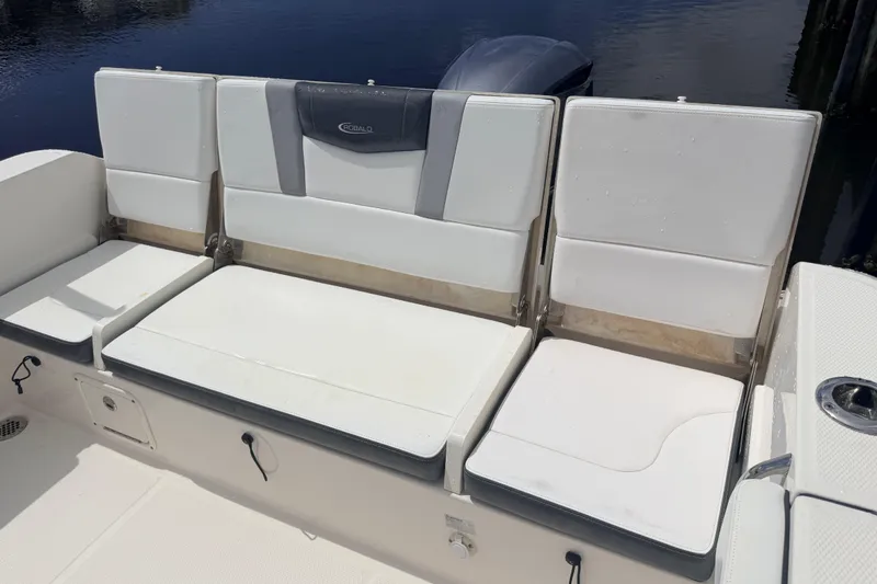 Slide: The Image of 2021 Robalo R230 Center Console boat seating with white cushions and storage compartments. - 25