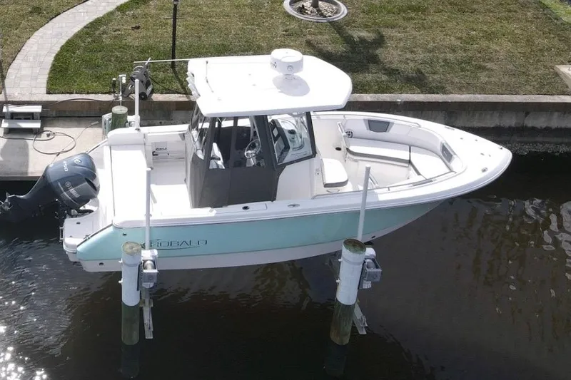 Slide: The Image of 2021 Robalo R230 Center Console boat docked, featuring sleek design and Yamaha outboard motor. - 8