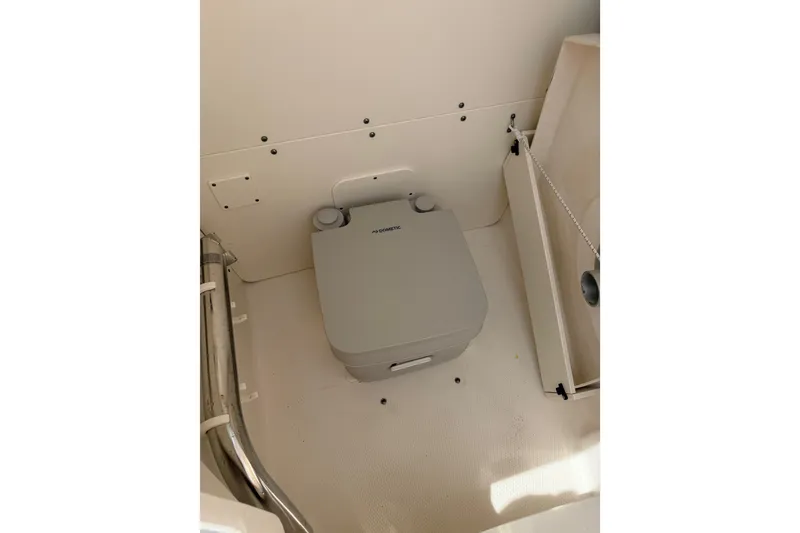 Slide: The Image of 2021 Robalo R230 Center Console boat interior with portable toilet. - 21