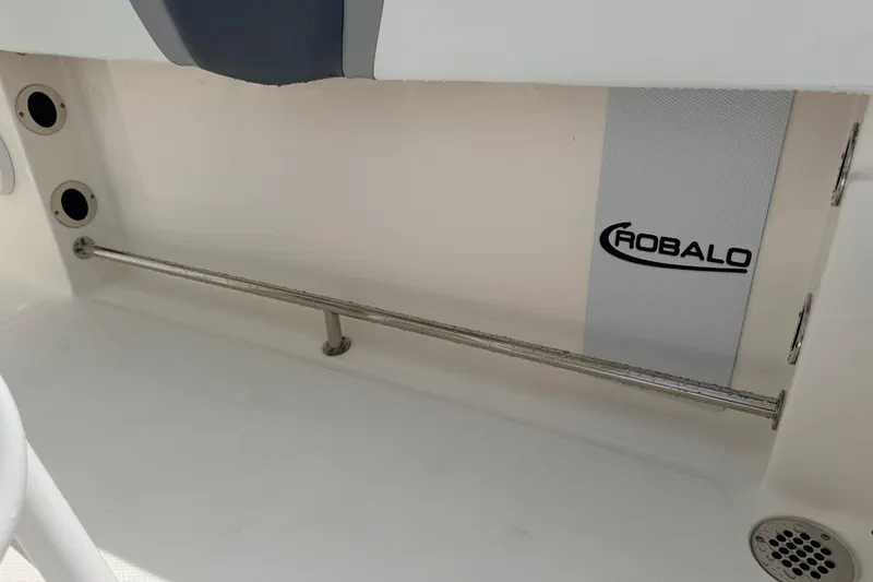 Slide: The Image of 2021 Robalo R230 Center Console interior detail with logo and stainless steel rod holder. - 29