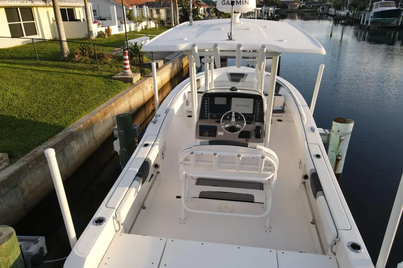 Slide: The Image of 2021 Robalo R230 Center Console boat docked by a canal, featuring Garmin navigation. - 5