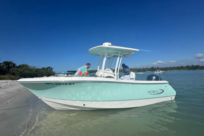 The Image of 2021 Robalo R230 Center Console boat docked on a sunny beach. - 0