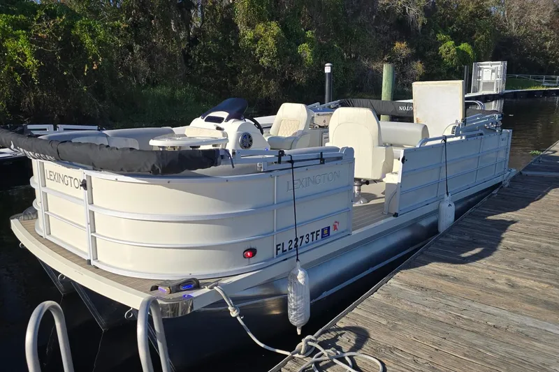 Slide: The Image of 2021 Lexington 521 5 Series pontoon boat docked by a wooden pier. - 2