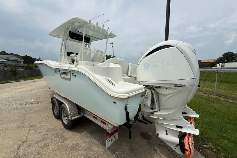 Slide: The Image of 2023 Key West 263 FS boat with Yamaha engine on a trailer, parked outdoors. - 1