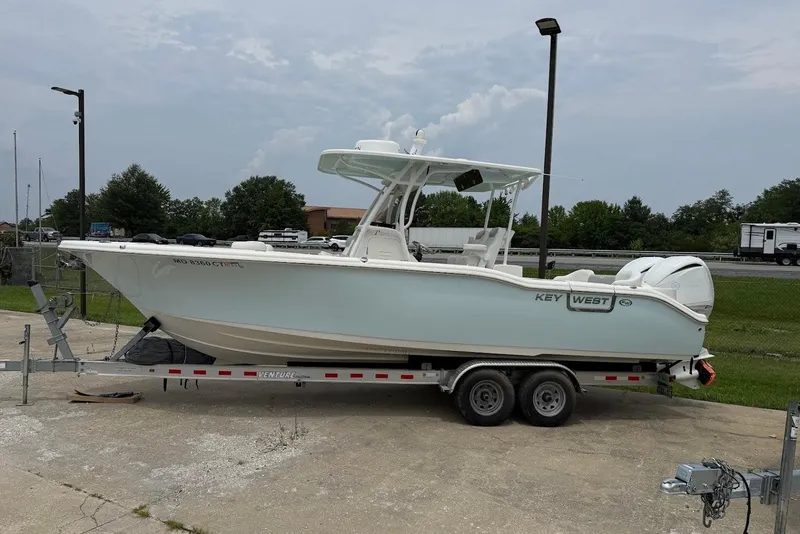 The Image of 2023 Key West 263 FS boat on trailer, parked outdoors under cloudy sky. - 0