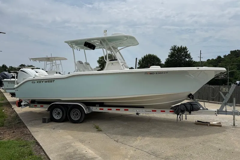 Slide: The Image of 2023 Key West 263 FS boat on trailer, parked outdoors, side view. - 4