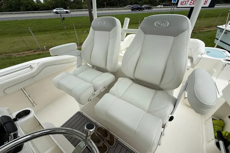 Slide: The Image of 2023 Key West 263 FS boat with white cushioned captain's chairs and steering wheel. - 13