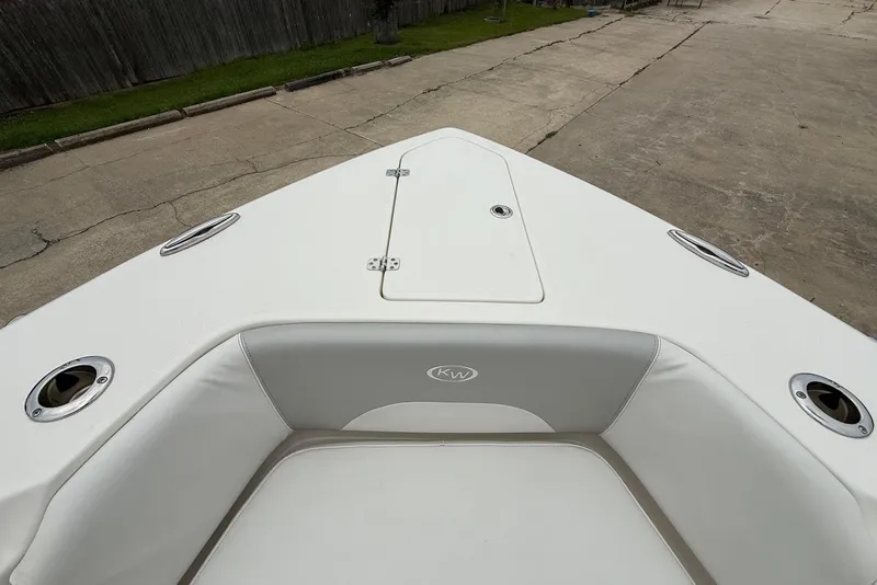 Slide: The Image of 2023 Key West 263 FS boat bow with cushioned seating and storage hatch. - 26