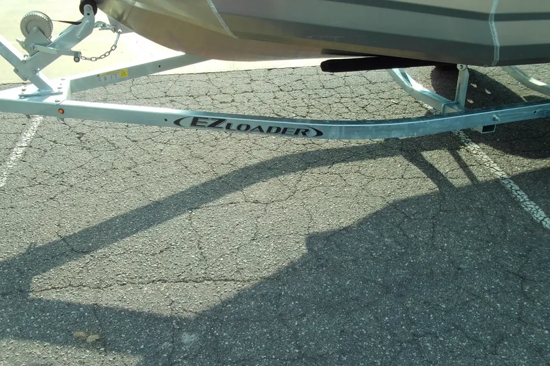 Slide: The Image of Trailer for 2025 Stabicraft 1450 Frontier boat on cracked pavement. - 15