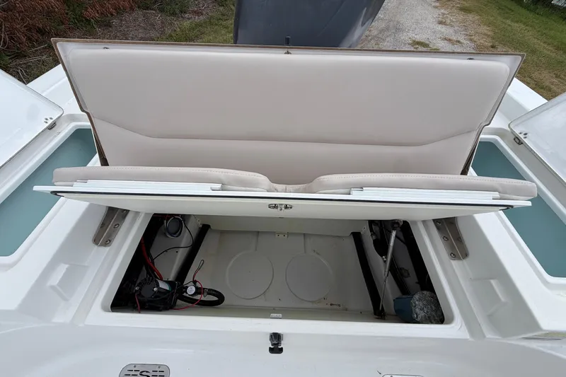 Slide: The Image of 2019 Sportsman Masters 227 Bay Boat storage compartment with open seat revealing interior. - 11