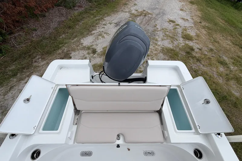 Slide: The Image of 2019 Sportsman Masters 227 Bay Boat with open storage compartments and outboard motor. - 10