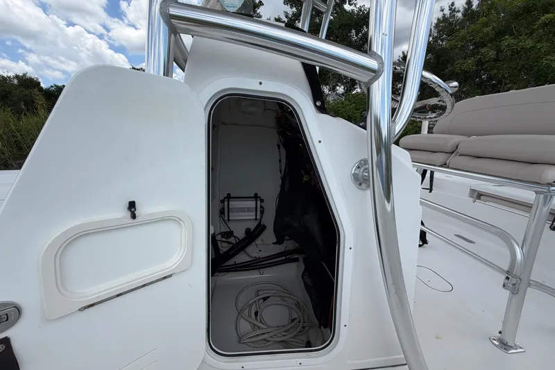 Slide: The Image of 2019 Sportsman Masters 227 Bay Boat storage compartment with open hatch and visible wiring. - 15