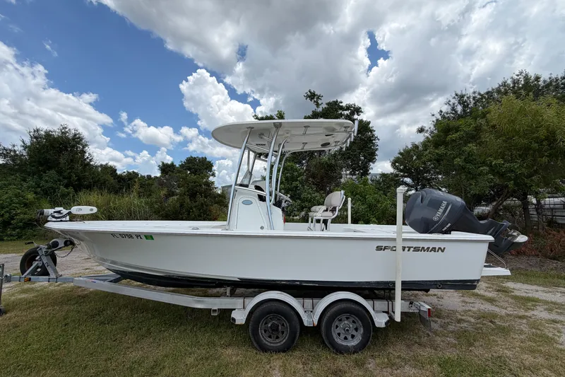 The Image of 2019 Sportsman Masters 227 Bay Boat on trailer, parked outdoors under cloudy sky. - 0
