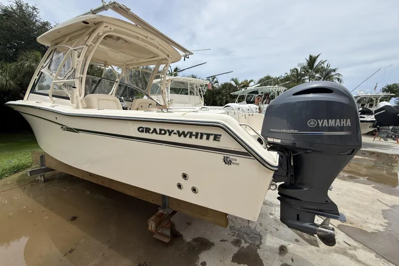 Slide: The Image of 2015 Grady-White Freedom 275 boat with Yamaha engine, parked outdoors. - 2