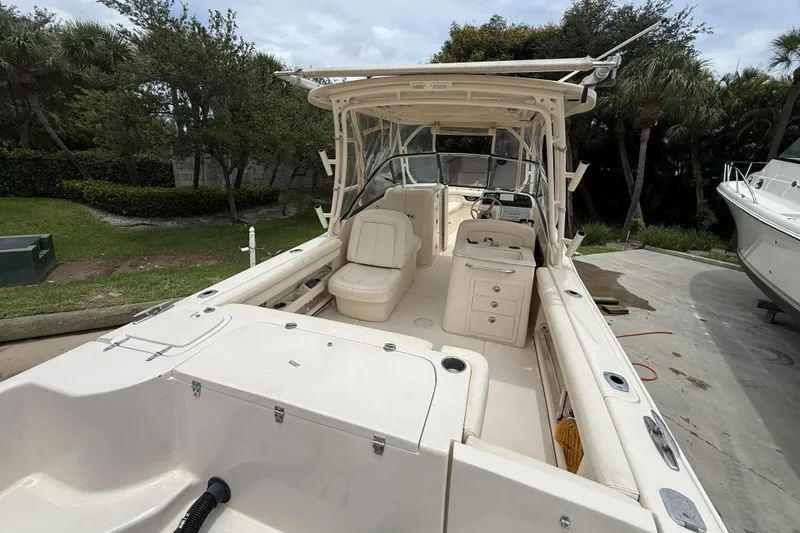 Slide: The Image of 2015 Grady-White Freedom 275 boat interior with seating and console, docked outdoors. - 8