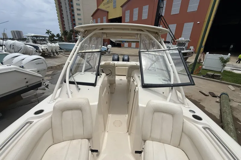 Slide: The Image of 2015 Grady-White Freedom 275 boat docked, showcasing spacious seating and dual console design. - 13