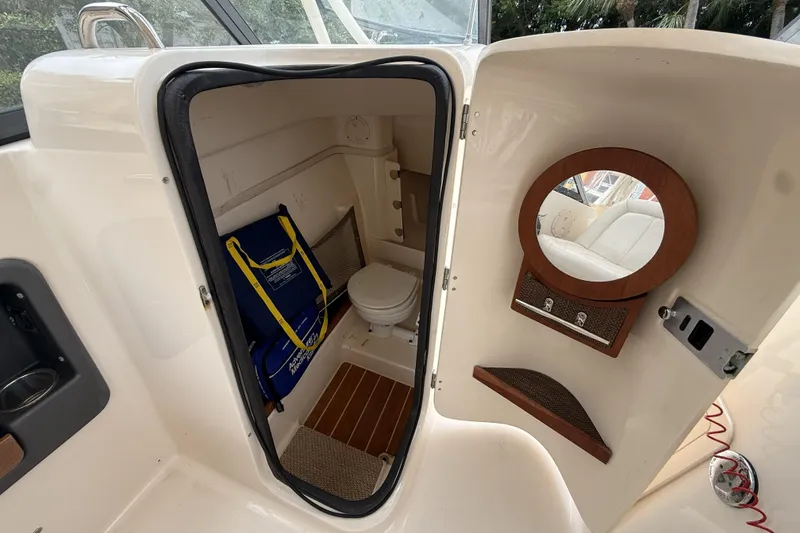 Slide: The Image of 2015 Grady-White Freedom 275 boat interior with compact bathroom and storage. - 16