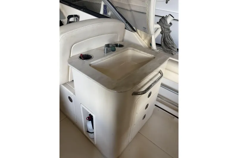 Slide: The Image of Interior of 2015 Grady-White Freedom 275 boat featuring a compact sink and storage area. - 17