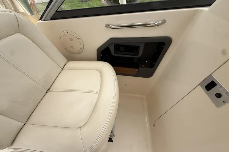 Slide: The Image of Interior of 2015 Grady-White Freedom 275 boat, featuring a comfortable seat and control panel. - 15