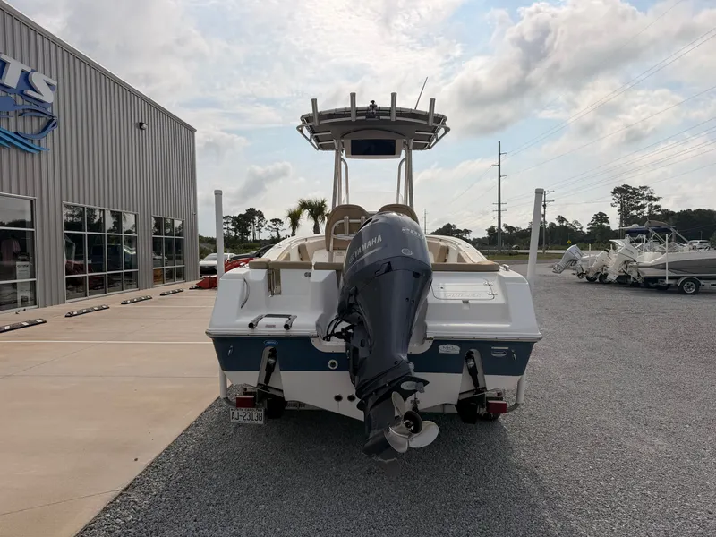 Slide: The Image of A 2016 Tidewater 220 LXF boat is parked on a gravel lot next to a building. - 3
