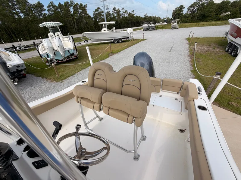 Slide: The Image of The image shows the cockpit of a Tidewater 220 LXF boat with beige seats and a steering wheel. - 12