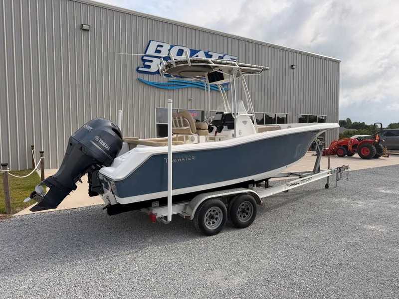 Slide: The Image of A 2016 Tidewater 220 LXF boat on a trailer in front of a building. - 2