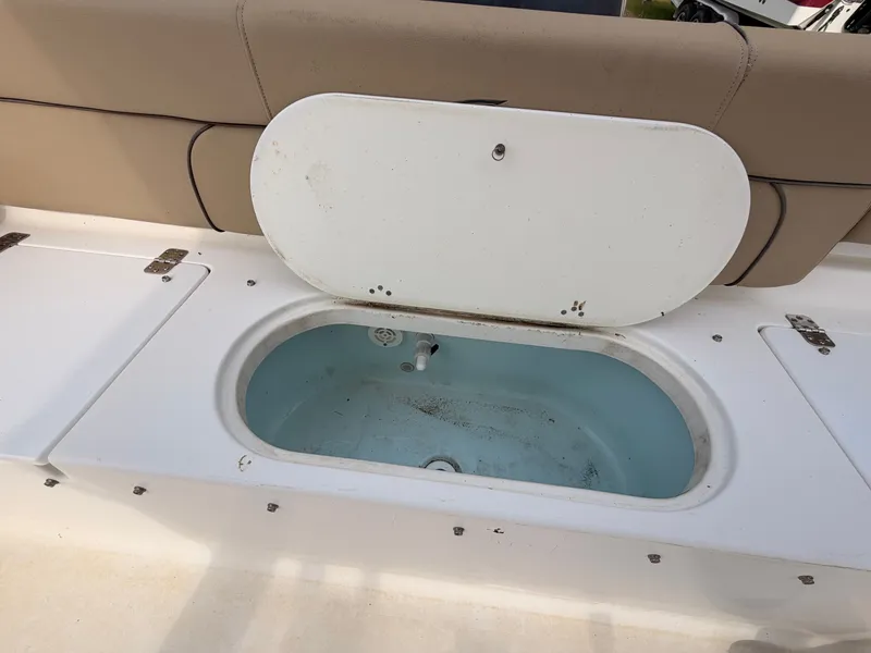 Slide: The Image of An open storage compartment on a boat with beige upholstery in the background. - 17
