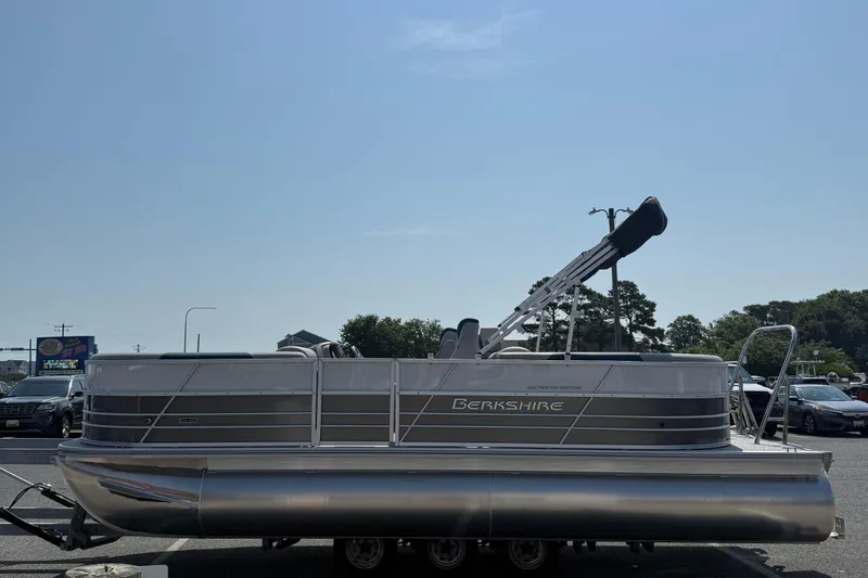 Slide: The Image of 2026 Berkshire 22RFX LE pontoon boat parked in a lot under clear blue sky. - 5