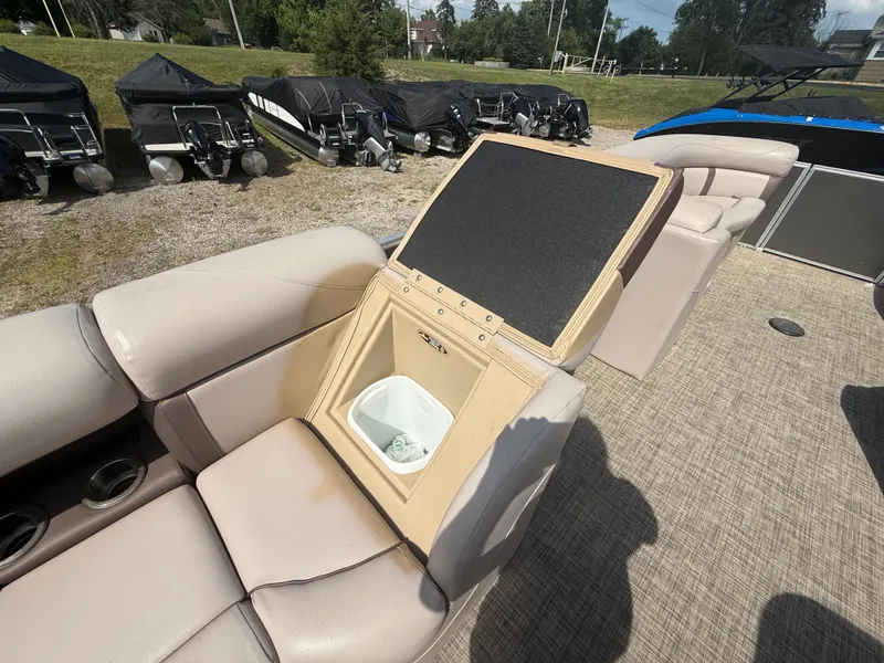 Slide: The Image of Interior of a 2018 Harris 240 CXCS Tritoon with beige upholstery and storage compartment. - 22