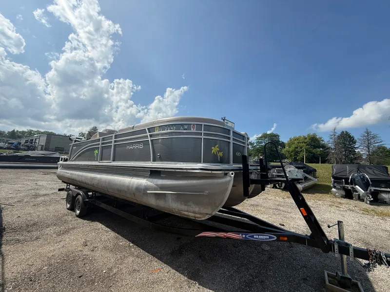 The Image of A 2018 Harris 240 CXCS Tritoon on a trailer under a cloudy sky. - 0