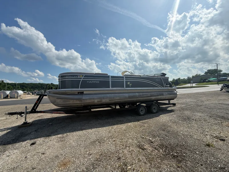 Slide: The Image of A 2018 Harris 240 CXCS Tritoon on a trailer in a parking lot. - 2