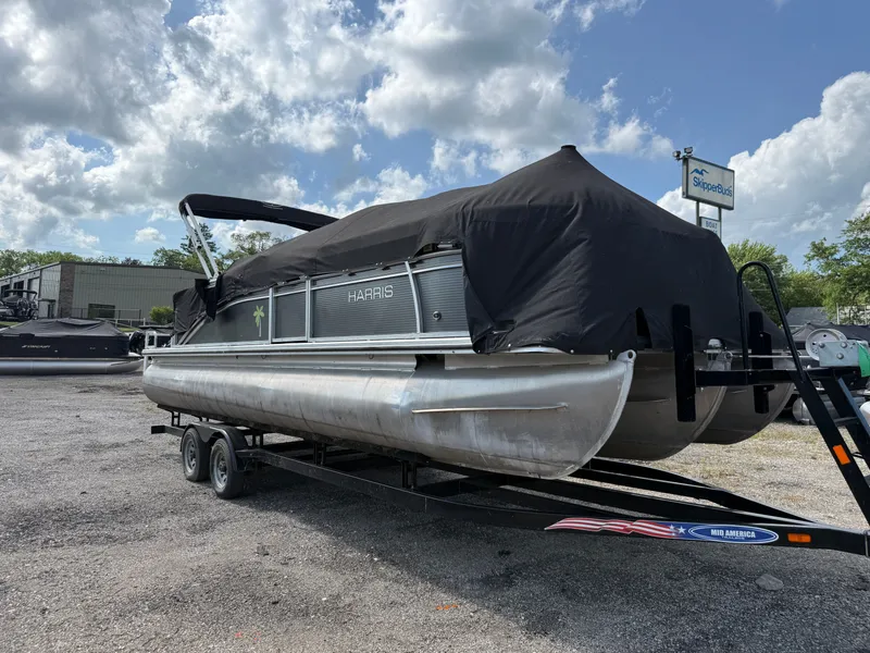 Slide: The Image of A 2018 Harris 240 CXCS Tritoon on a trailer, covered with a black tarp. - 25