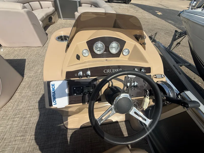 Slide: The Image of The image shows the helm of a 2018 Harris 240 CXCS Tritoon with a steering wheel and gauges. - 14