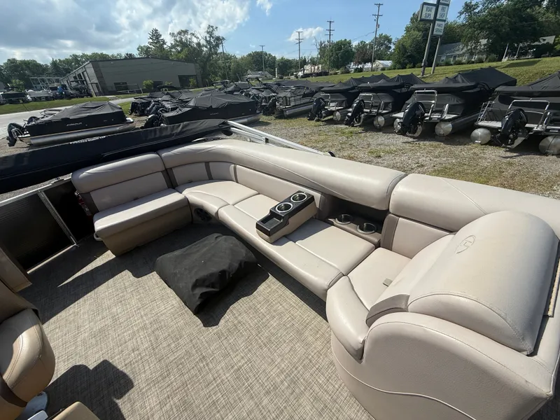 Slide: The Image of Interior view of a 2018 Harris 240 CXCS Tritoon with beige seating and cup holders. - 11