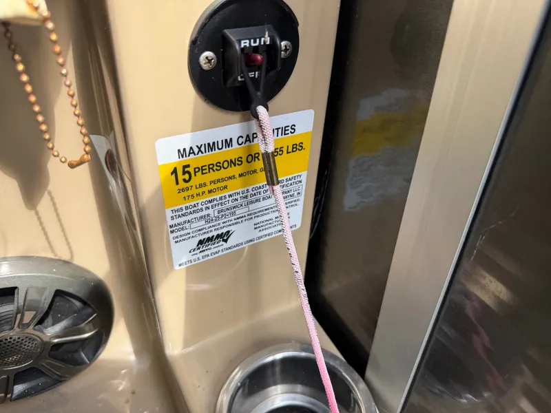 Slide: The Image of Close-up of a boat part with a warning label for maximum capacity of 15 persons. - 24