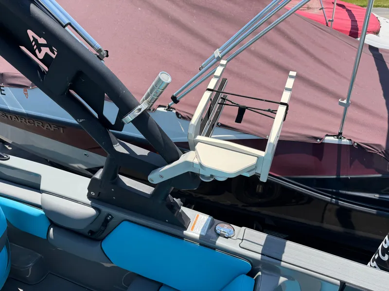 Slide: The Image of A boat with blue seats and a black frame. It is docked next to another boat. - 25