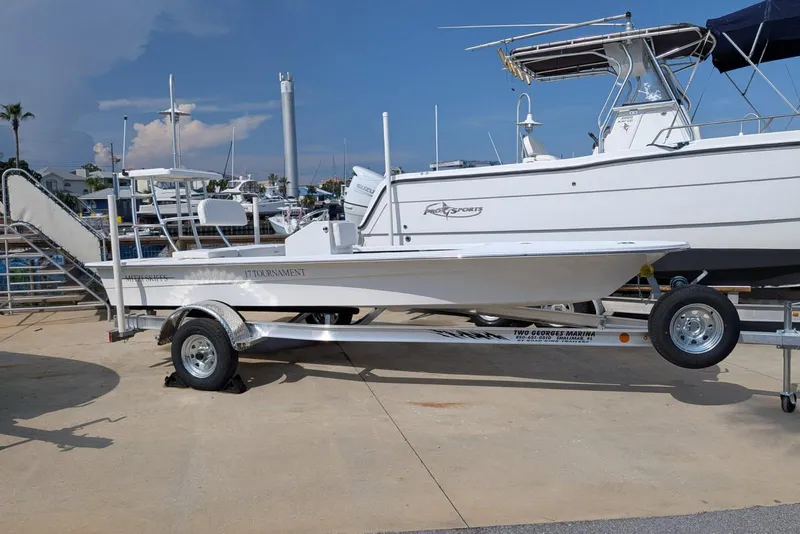 The Image of 2026 Mitzi Skiffs 17 Tournament boat on trailer at marina, clear sky background. - 0
