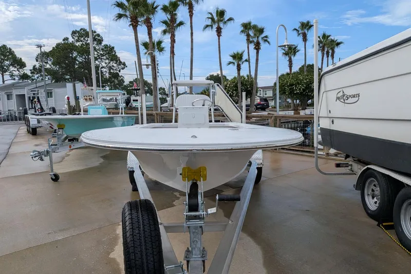 Slide: The Image of 2026 Mitzi Skiffs 17 Tournament boat on trailer, surrounded by palm trees and other boats. - 6