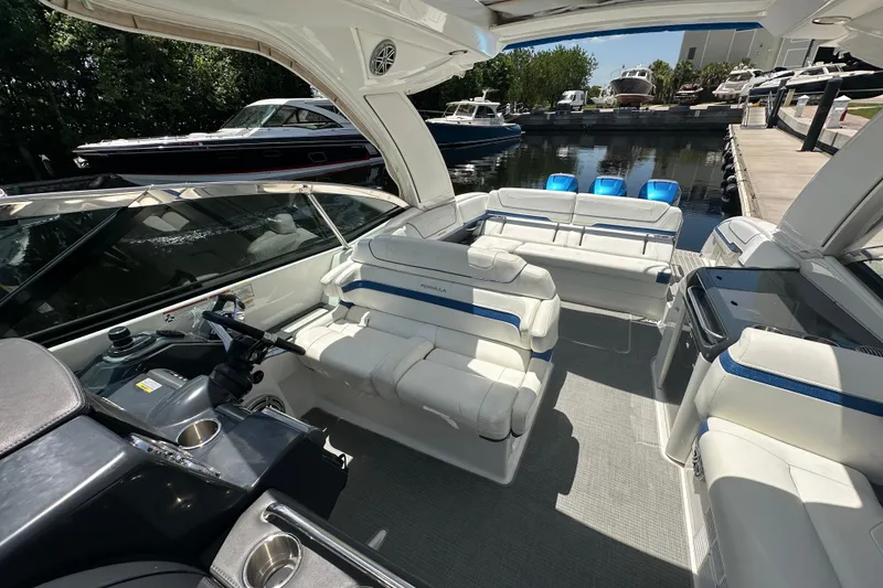 Slide: The Image of 2018 Formula 350 Crossover Bowrider OB with luxurious seating and sleek design at a marina. - 31