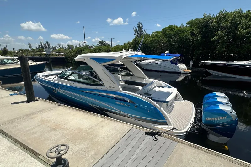 Slide: The Image of 2018 Formula 350 Crossover Bowrider OB docked, featuring sleek design and twin Mercury outboards. - 13
