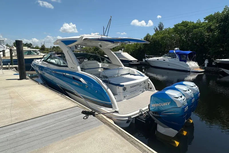 Slide: The Image of 2018 Formula 350 Crossover Bowrider OB with Mercury engines docked by the water. - 4