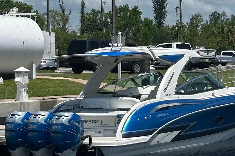 Slide: The Image of 2018 Formula 350 Crossover Bowrider OB with triple outboard engines docked. - 2