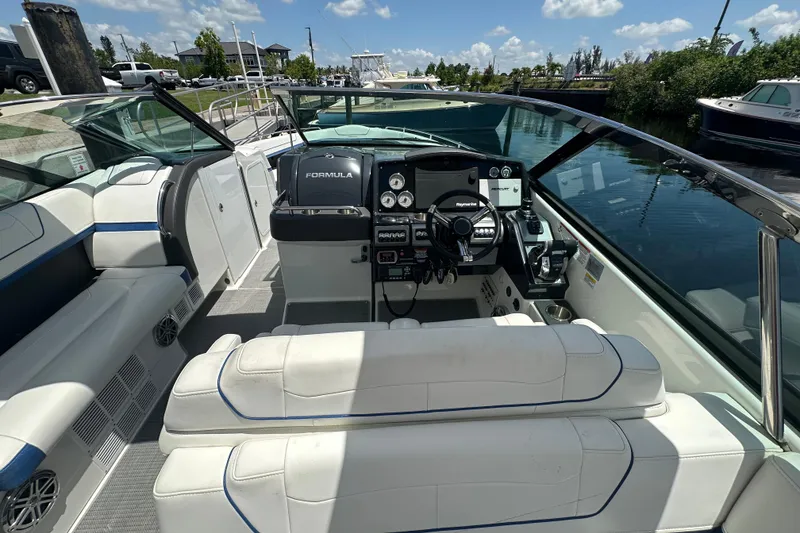 Slide: The Image of 2018 Formula 350 Crossover Bowrider OB interior with helm, seating, and water view. - 28