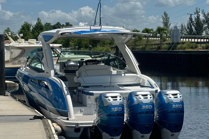 Slide: The Image of 2018 Formula 350 Crossover Bowrider OB with triple outboard engines docked by the water. - 8
