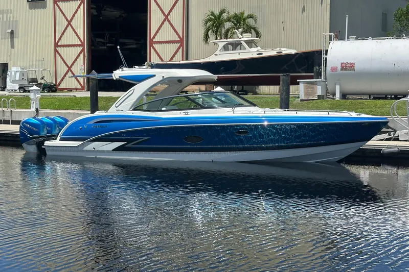 Slide: The Image of 2018 Formula 350 Crossover Bowrider OB in marina, blue hull, docked near warehouse. - 1